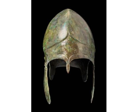 Ca. 500 BC.
A striking Chalcidian helmet comprised of hammered tinned bronze, so named as this helmet form was initially depi