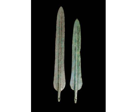 Ca. 1200 - 800 BC.
A pair of cast bronze daggers. The weapons have dual, tapered edges leading to a pointed tip, with a shall