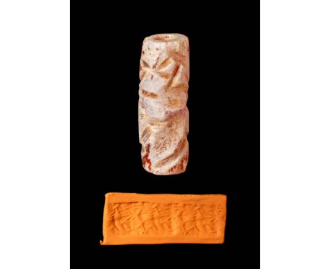 Ca. 800 - 600 BC.
A cylinder seal of burnt carnelian depicting an archer on one knee aiming his bow at a reared-up horned qua