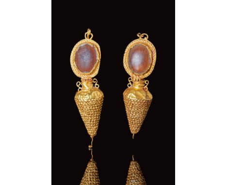 Ca. 300 - 200 BC.
A pair of Hellenistic gold amphora shaped earrings. Each earring features a hanging amphora attached to con