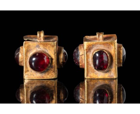 Ca. 300 - 100 BC.
A matched pair of gold earrings, each features a distinctive cube shape, embellished with smooth red garnet