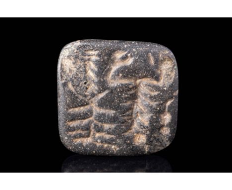 Ca. 1400 - 1100 BC.A Near Eastern black stone stamp seal, square flat face, back rising to pierced tip with grooves around th