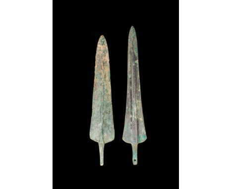 Ca. 1200 - 800 BC.
A pair of cast bronze daggers. The weapons have dual, tapered edges leading to a pointed tip, with a shall