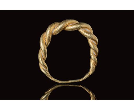 Ca. AD 800 - 1100.A ring with twisted wires and a solid shank made from gold. The top portion features four pairs of twisted 