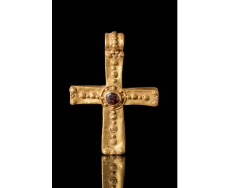 Ca. AD 600 - 900.
A splendid gold cross pendant, adorned with a large garnet cabochon in the centre. The arms are decorated w