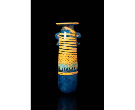 Ca. 500 BC.
A striking core-formed glass alabastron. This vessel is comprised of cobalt-blue glass with yellow trailing combe