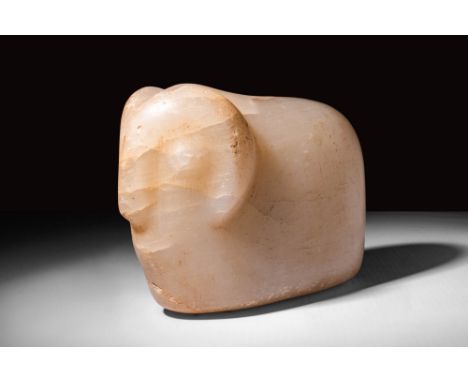 Ca. 1st century BC.
An alabaster stylised figure of a ram, featuring a flat base and gently rounded back. The head of the ani