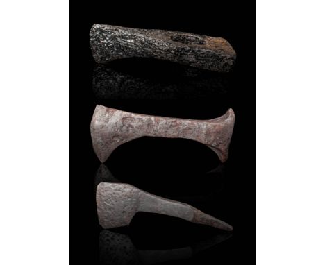 Ca. AD 800 - 1100.
An iron axe-head with a narrow sub-triangular asymmetric blade and rounded edge. The top of shaft-hole col