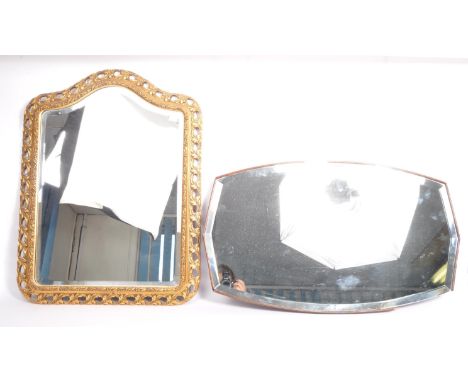 A vintage retro mid 20th century wall mirror having ornate pierced wooden frame with rocaille motifs, floral decoration and g