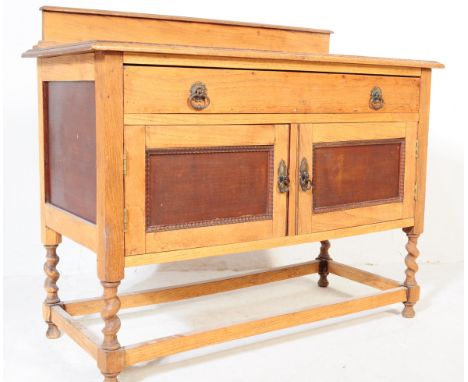 A 1920's golden oak sideboard - credenza. Raised on barleytwist turned legs united by stretchers having twin doors under long
