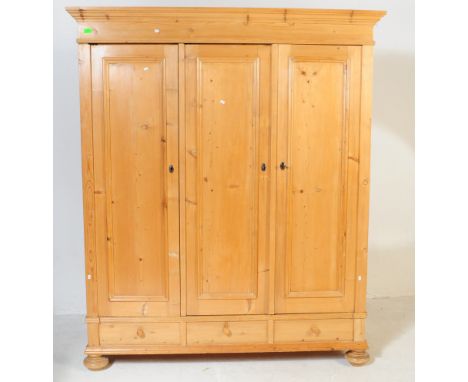 A 20th century Scandinavian pine pine triple wardrobe armoire. Of good size, the wardrobe being raised on shaped feet with a&