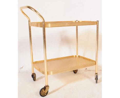 A Vintage mid century gold coloured two tier drinks / tea trolley. The trolley on good castors, handle to one end. Both trays