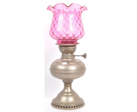 A 20th century German oil lamp having pierced trefoil and gadrooned decoration to base and reservoir with flute and cranberry