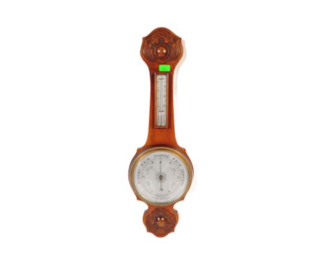 A 1920's oak and milk glass aneroid banjo shaped wall barometer with thermometer to the neck and finished with a carved &amp;