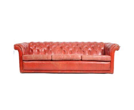 A vintage 20th century red leather Chesterfield button backed three seater sofa settee having scrolled arms and backrest with