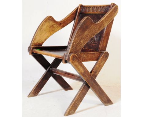 A late 19th Victorian solid oak Glastonbury chair in the ecclesiastical style, the back panel with carved lozenge decoration 