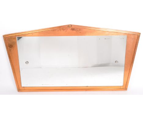 An early 20th century Arts and Crafts hammered copper plate wall mirror. The mirror having central rectangular mirror glass p