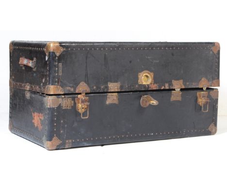 A vintage 20th century railway travel trunk suitcase. Of rectangular form with brass bound and stud work. Twin leather carry 