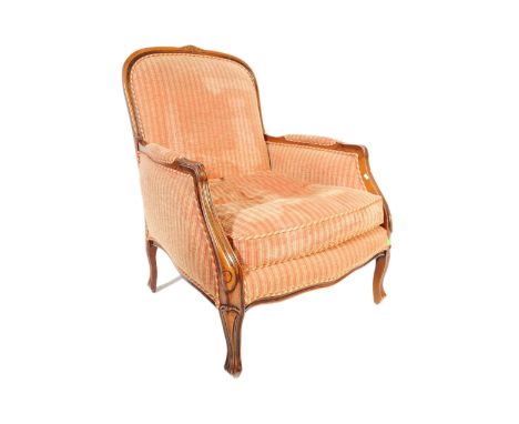 A vintage 20th century French fire side lounge arm chair. Having a curved rectangular back rest with carved motifs to top. Pa