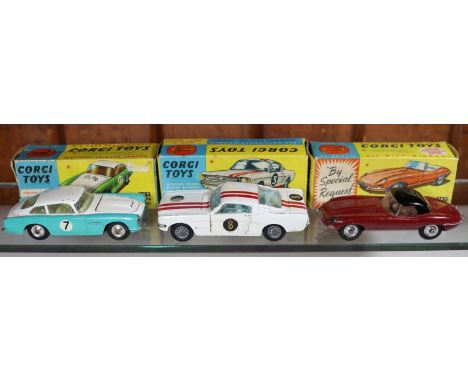 3 Corgi Toys. 'E' Type Jaguar (307). In maroon with brown interior and detachable black plastic roof. Plus an Aston Martin Co