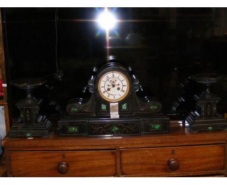A Victorian slate and green marble mantel clock with visible escapement and matching side urns CONDITION REPORTchips to corne