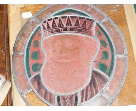 An antique stained glass panel depicting medieval king