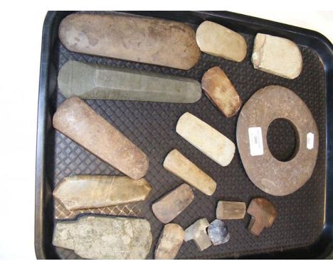 An assortment of antiquarian stone axe heads, etc., including a disc 