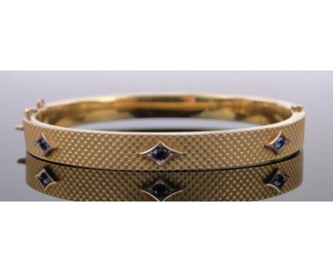 A 9ct gold hinged bangle,set with 3 sapphires, 8.5g