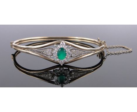 An unmarked gold gemstone set hinged bangle