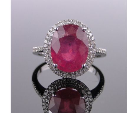A 14ct white gold ruby and diamond cluster ring,ruby approx 5.3cts, diamond content approx 0.65cts, setting height 15mm, size