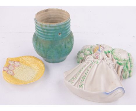 3 Pieces of Clarice Cliff pottery,comprising a relief embossed wall pocket, height 7", a mottled blue pottery lamp base and a