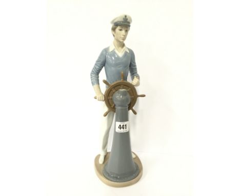 A Lladro china figure modelled as a Young Sailor turning a ship's wheel.