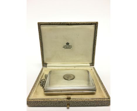 An early 20th century engine turned ladies' silver compact with fitted interior containing double powder compartment, mirror,