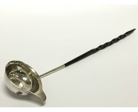 A silver Toddy ladle with twist stem and inset coin decoration.