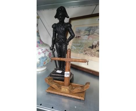A cast iron door stop modelled as Napoleon Bonaparte, together with a carved oak pipe rest modelled as an anchor, souvenir of