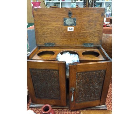 An early 20th century oak smoker's cabinet with carved panel doors and fitted interior together with a carved mahogany cased 