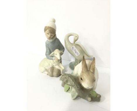 A small Lladro china figure modelled as a Young Boy holding a lamb together with another modelled as a rabbit and a small Lla