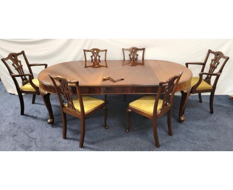 EARLY 20th CENTURY OAK EXTENDING DINING TABLE AND SIX CHAIRSthe table with three leaves, plain frieze and raised on carved ca