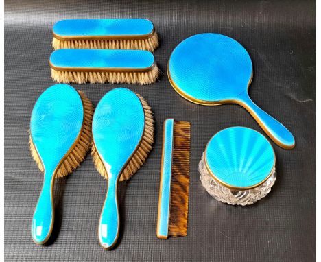 GILT METAL AND GUILLOCHE ENAMEL DRESSING TABLE SETcomprising four brushes, comb, hand mirror and jar, with bright blue enamel