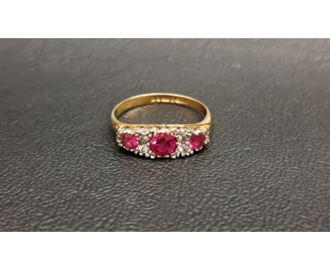 RUBY AND CLEAR GEM SET RINGthe three graduated round cut rubies separated by small clear gemstones, the central ruby approxim