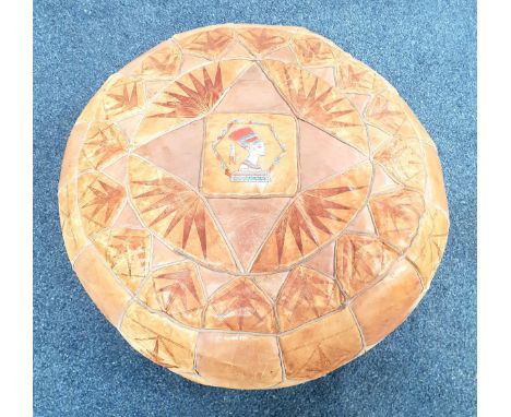 VINTAGE LEATHER POUFFEthe patchwork stool with central Egyptian head detail and further tooled decoration, 64cm diameter 