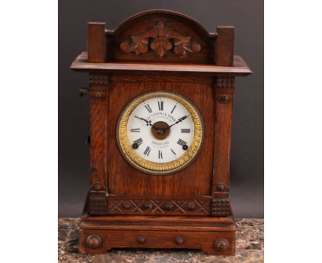 An early 20th century oak mantel alarm clock, 11.5cm circular enamel dial inscribed FATTORINI &amp; SONS, PATENT AUTOMATIC AL