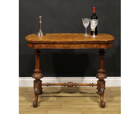 A Victorian walnut serpentine card table, hinged quarter-veneered top enclosing a baize lined playing surface, turned support