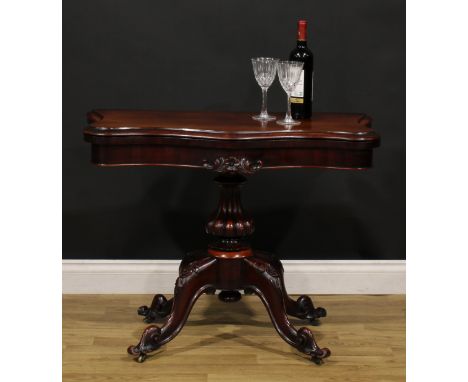 A Victorian mahogany serpentine card table, hinged top with moulded edge enclosing a baize lined playing surface, fluted colu