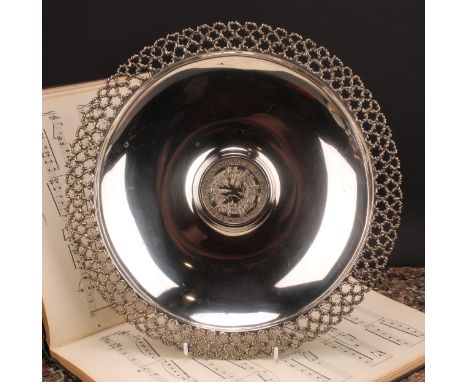 Stuart Devlin (1931 - 2018) - an Elizabeth II silver shaped circular table centrepiece dish, the central boss commemorating t