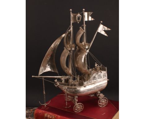 A Dutch silver nef, typically cast and wrought as a two-masted sailing ship, with billowing sails and scroll-spoked wheels, 4