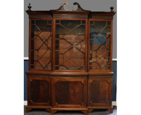 A Chippendale Revival mahogany break-centre library bookcase, astragal glazed doors, the projecting base with panel doors, ou