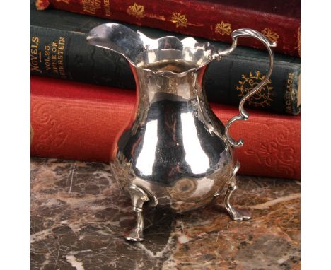 A George III silver baluster cream jug, wavy rim, acanthus-capped scroll handle, shaped pad feet, 10cm high, maker IS &amp; A