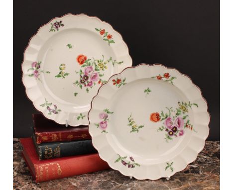 A pair of Worcester shaped circular plates, painted in polychrome with scattered flowers and sprigs, brown lines to rims, 22c