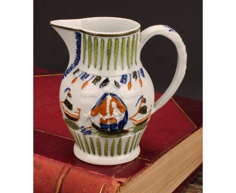 A Prattware pearlware jug, moulded in relief with Lord Jarvis flanked by a pair of ships, hand tinted in green, blue and ochr